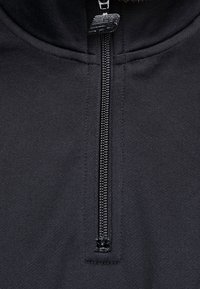 Černý fleecový svetr na zip s dobře tvarovaným límcem, vybavený pevným zipem a texturovaným povrchem látky.