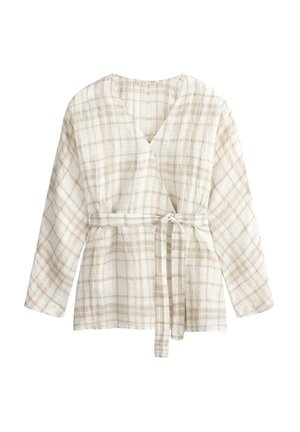 Fehér és bézs kockás átlapolt blúz hosszú ujjakkal és derékban megkötött textil övvel.