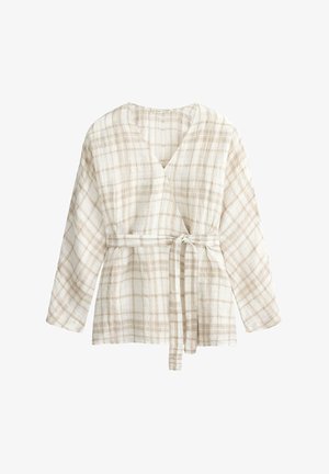 Fehér és bézs kockás átlapolt blúz hosszú ujjakkal és derékban megkötött textil övvel.