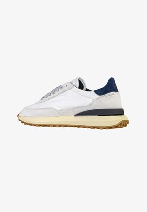 Sneaker bianca e beige con lacci grigio chiaro, linguetta sul tallone blu navy e suola beige strutturata, mostrata in profilo laterale destro.