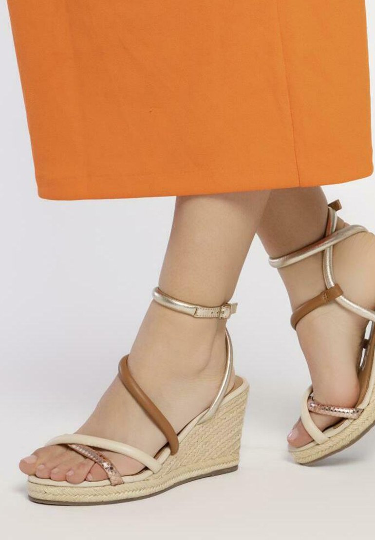 Sandalias de cuña con suela de yute trenzado, con correas en beige, marrón y metálicas. El detalle de la correa en el tobillo mejora el cierre y el soporte.