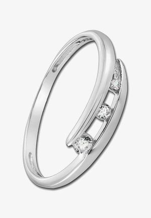 Bague ouverte en argent avec trois petites pierres précieuses rondes et transparentes serties sur un côté.