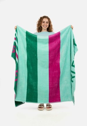 Turquoise gestreepte strandhanddoek met gedurfde groene en roze strepen, zachte textuur, groot formaat en tekst langs de rand.