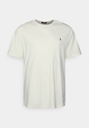 Baumwoll-T-Shirt in Off-White, Rundhalsausschnitt, kurze Ärmel, mit kleinem braunem Sticklogo auf der Brust. Einfaches und schmuckloses Design.