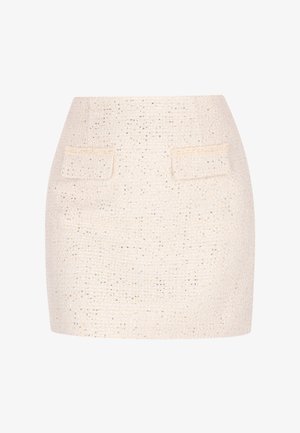 Short cream skirt made of textured fabric with metallic threads. Features two back pockets and a fitted silhouette.