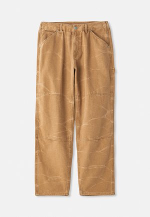 Pamučne hlače bež boje sa slobodnim krojem, s vidljivim šavovima, detaljima u obliku zakrpa i lagano naboranom teksturom.