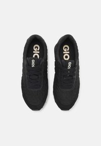 Scarpe sportive nere con tomaia testurizzata, punta rotonda, lacci piatti, suole interne imbottite e marchio "GIOS" sulla linguetta. Suole in gomma.