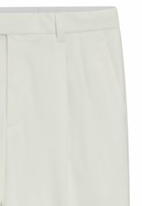 Pantaloni bianchi plissettati realizzati in un tessuto liscia. Presentano una vita con chiusura a gancio, tasche laterali e una vestibilità sartoriale.