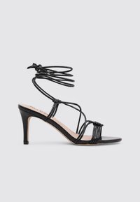 Sandalias de tacón alto negras con tiras, con la puntera abierta, que presentan un intrincado detalle de lace-up y un tacón delgado. Acabado de piel sintética lisa.