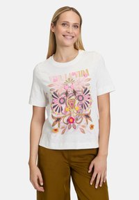 Weißes T-Shirt mit kurzen Ärmeln und floralem Grafikdesign in Pink, Gold und Grün. Verfügt über lebendige, gestickte Akzente und einen lockeren Schnitt.