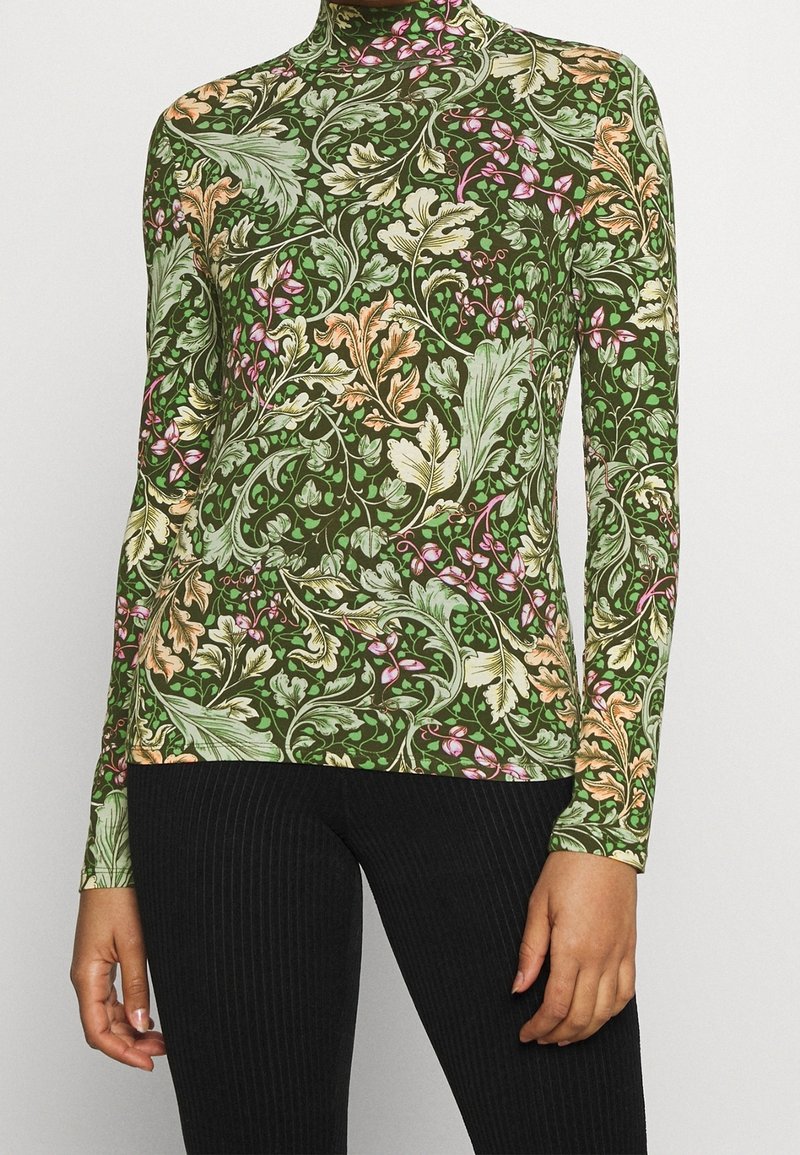 Grön långärmad topp med ett blommönster med blad och blommor i rosa, orange och krämfärgade nyanser. Hög, figurnära halsdesign.