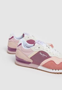 Sport skor med en blandning av rosa och lila nyanser, med en överdel i mocka och mesh, vita snören och en texturerad gummisula.