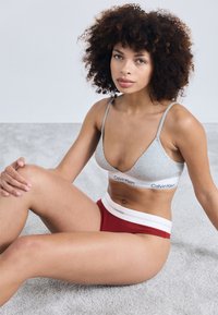 Hallux hallux järgipärane hall puuvillane bralette õhukeste rihmadega ja valge vöökoht, koos punaste soonikkäikega aluspükstega, millel on valge bänd, bränditud Calvin Klein.