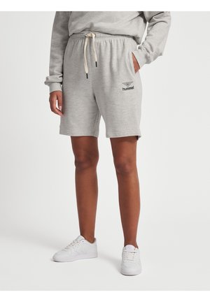 Personne portant un short hummel gris clair avec cordon, un sweat assorti et des baskets blanches, debout devant un fond uni.
