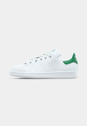 White sneaker with green accents, smooth leather material, rounded toe, flat sole, and perforated side detailing. Classic lace closure design.