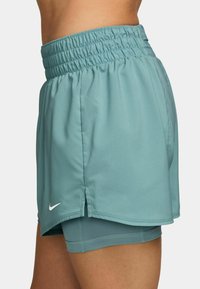Pantalones cortos de running en un tono azul claro con cinturilla elástica y forro interior. Presenta aberturas laterales para mayor movilidad y un pequeño logo blanco cerca del dobladillo.