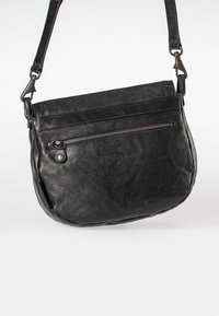 Borsa a tracolla in pelle nera con forma arrotondata, chiusura con zip superiore, tasca con zip frontale e tracolla regolabile. Texture liscia, hardware minimale.
