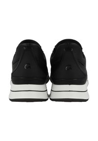 Black athletic shoes with a smooth leather finish, contrasting white midsole, and a logo detail on the heel. Minimalist design and shape.