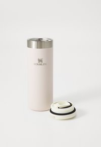 Mug de voyage en acier inoxydable avec une finition mate rose clair, un couvercle argenté et un bouchon blanc avec un accent noir pour une consommation facile.