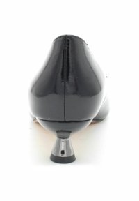 Tacco in vernice nera, con una curva elegante e una texture lucida, e un accent metallic alla base del tacco.