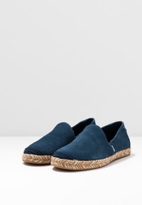 Espadrilles de ante azul marino con suelas de yute trenzado; diseño de punta en forma de almendra con acentos textiles azul marino en la parte delantera.