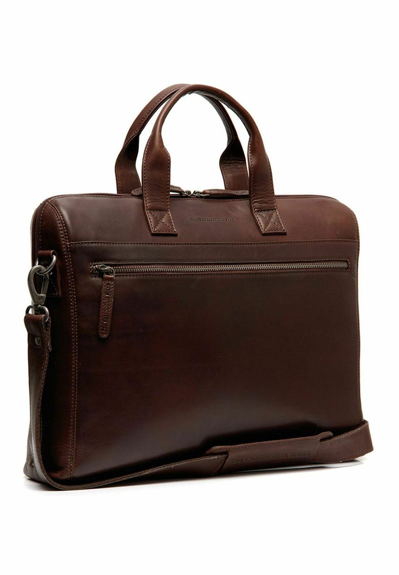 Serviette en cuir brun avec doubles poignées, une bandoulière amovible et une poche zippée extérieure, présentant une texture lisse et un design minimaliste.