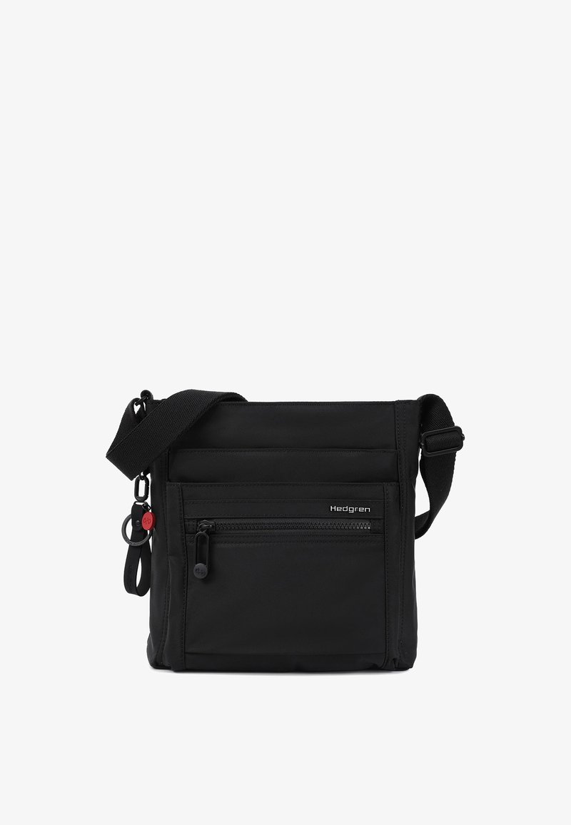 Sac bandoulière noir avec une sangle d'épaule ajustable, poche zippée à l'avant, petit logo Hedgren et porte-clés attaché avec une touche rouge.