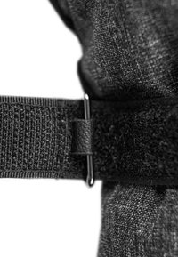 Schwarzes Stoffband mit strukturiertem Oberflächen, das mit einem Lederakzent und einem Metallclip versehen ist. Das Material wirkt langlebig und flexibel.