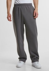 Sive, ležerne sweatpants hlače s elastičnim pojasom, bočnim džepovima i suženim nogavicama, napravljene od meke mješavine pamuka.