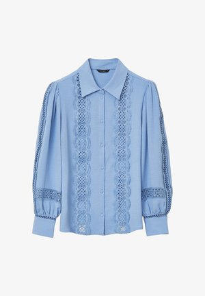 Blouse à manches longues bleu clair avec des détails en dentelle sur le devant et les manches, un col pointu et une fermeture à boutons.