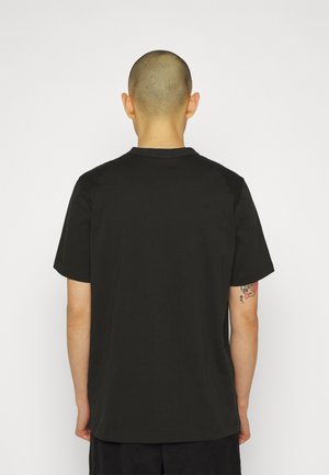 T-shirt en coton noir, manches courtes, col rond, texture lisse, design uni, vue arrière, sans étiquettes ni accents visibles.