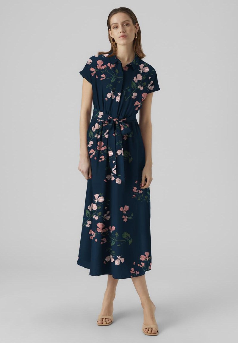 Maxikleid aus navy-blauem Stoff mit pinken und grünen Blumenmustern, kurzen Ärmeln, Kragen und einem Taillenzugdetail. Glatte Stoffoberfläche.