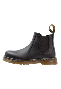 Black Chelsea boot made of smooth leather with elastic side panels, yellow welt stitching, and a textured rubber sole.
