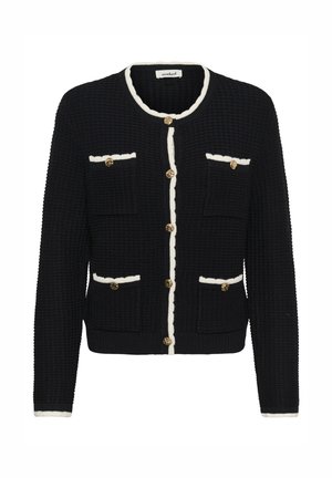 Mustard küllatud kardigan kreemjate äärtega, millel on kaks rinna taskut, kuldsed nupud ja ümmargune kaelus. Tekstureeritud kangas üle kogu.