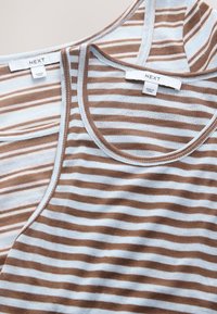 Two brown and white striped sleeveless tops with round necklines and small white tags labeled "NEXT" and "Made in China."