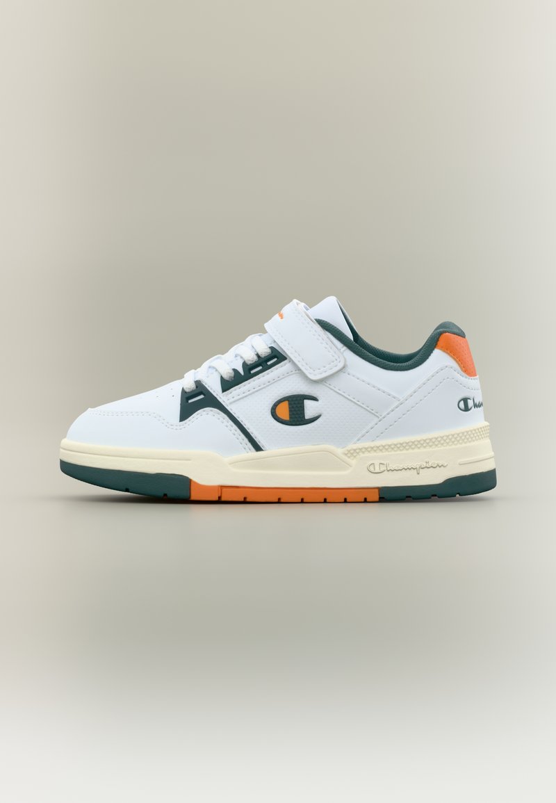 Λευκό αθλητικό παπούτσι με πράσινες λεπτομέρειες, λουράκι βέλκρο, υφασμένα πάνελ και πορτοκαλί λεπτομέρειες στη φτέρνα. Λαστιχένια σόλα για καλύτερη πρόσφυση.