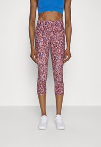 Rosa och lila mönstrade capri leggings med en slät textur, som har hög midja och en tight design, kombinerat med vita träningsskor.