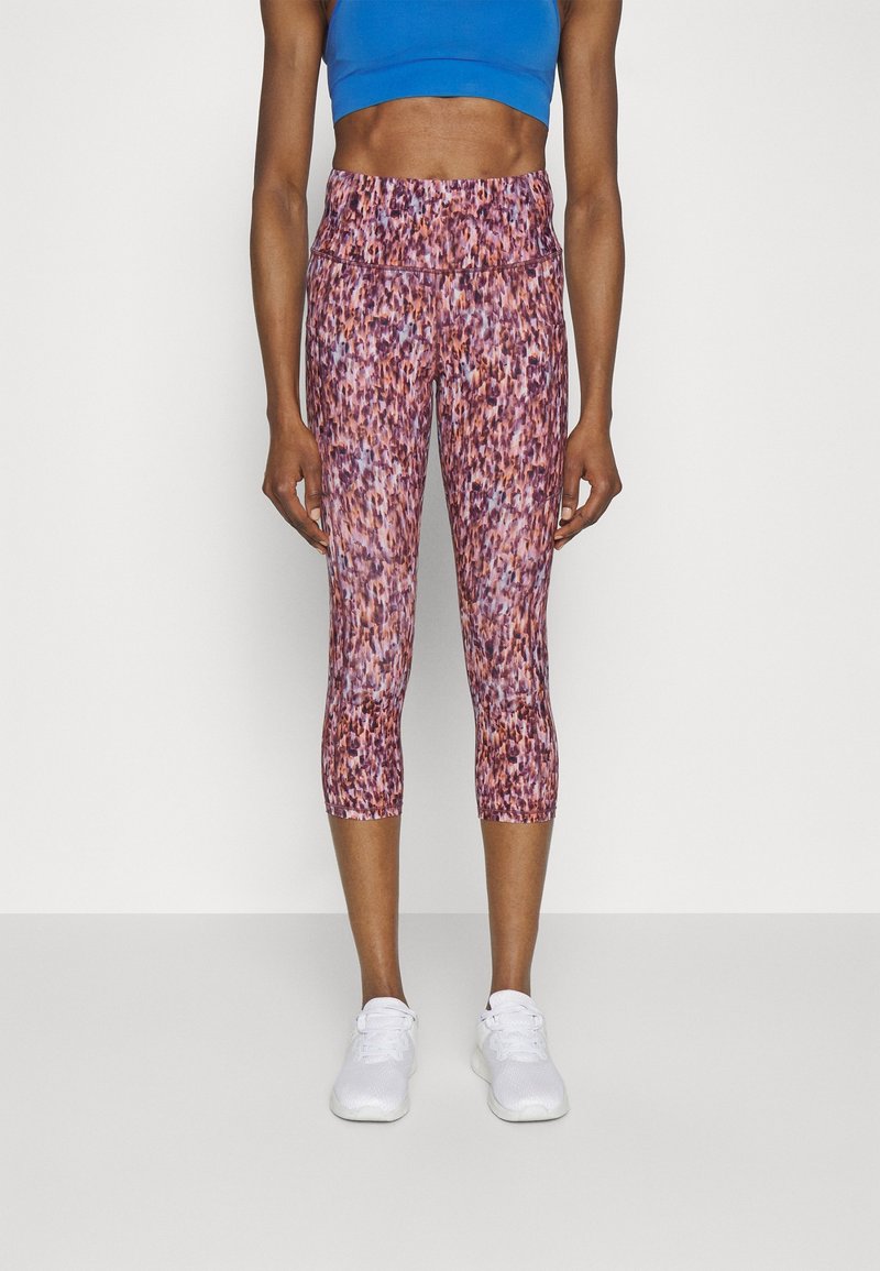 Rosa och lila mönstrade capri leggings med en slät textur, som har hög midja och en tight design, kombinerat med vita träningsskor.