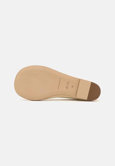 Semelle de chaussure en cuir beige avec une texture lisse, dotée d'un accent marron au talon. Les marquages incluent les détails de la marque et la taille.