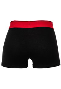Boxer shorts en coton noir avec une large ceinture élastique rouge et des accents noirs, présentant une texture lisse et une coupe classique.
