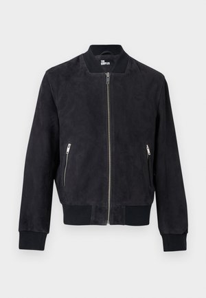 Blouson aviateur en daim noir avec fermeture éclair frontale, poches latérales zippées, col, poignets et ourlet côtelés, marqué à l'intérieur du col.