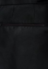 Pantaloni neri sartoriali con una texture liscia e motivo a righe sottili, dotati di una tasca posteriore singola con un sottile bordo nero.