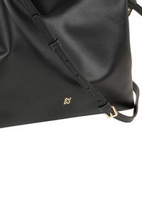 Borsa a tracolla in pelle nera con design morbido, tracolla regolabile e accento logo color oro. Texture liscia con uno stile minimalista.