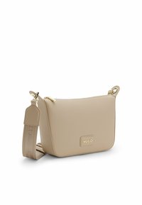 Sac bandoulière en cuir beige avec une forme structurée, une quincaillerie dorée, une fermeture éclair et un patch logo de marque à l'avant. Bretelle réglable.