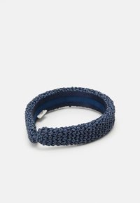 Tamsiai mėlyna nertinė galvos juosta su tekstūruota paviršiumi ir lygiu vidiniu pamušalu patogumui. Itin stora, apvalios formos dizainas.