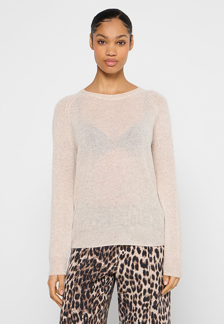 Helles rosa Sweatshirt aus einem weichen, strukturierten Strick mit rundem Halsausschnitt und langen Ärmeln, kombiniert mit einer Hose im Leopardenmuster.