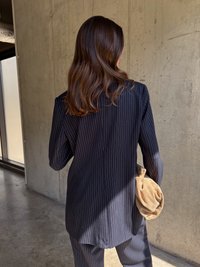 Jūrinės juostuotos švarkas pagamintas iš pritaikyto audinio, su pečių pagalvėlėmis ir šiek tiek ilgesniu nugaros kraštu. Suderintas su švelnia smėlio spalvos rankine.