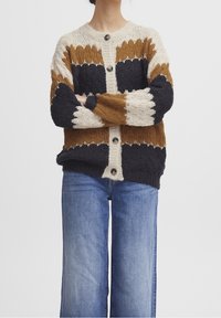 Stickad cardigan med flerfärgade ränder i brun, krämfärgad och marinblå. Har en knappstängning, ribbat mönster och vida ärmar.