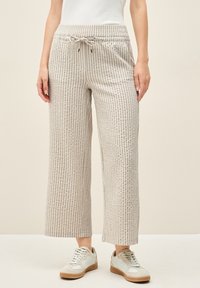 Light beige wide-leg pants with vertical stripes and a textured fabric. Features an elastic waistband with a drawstring and side pockets.