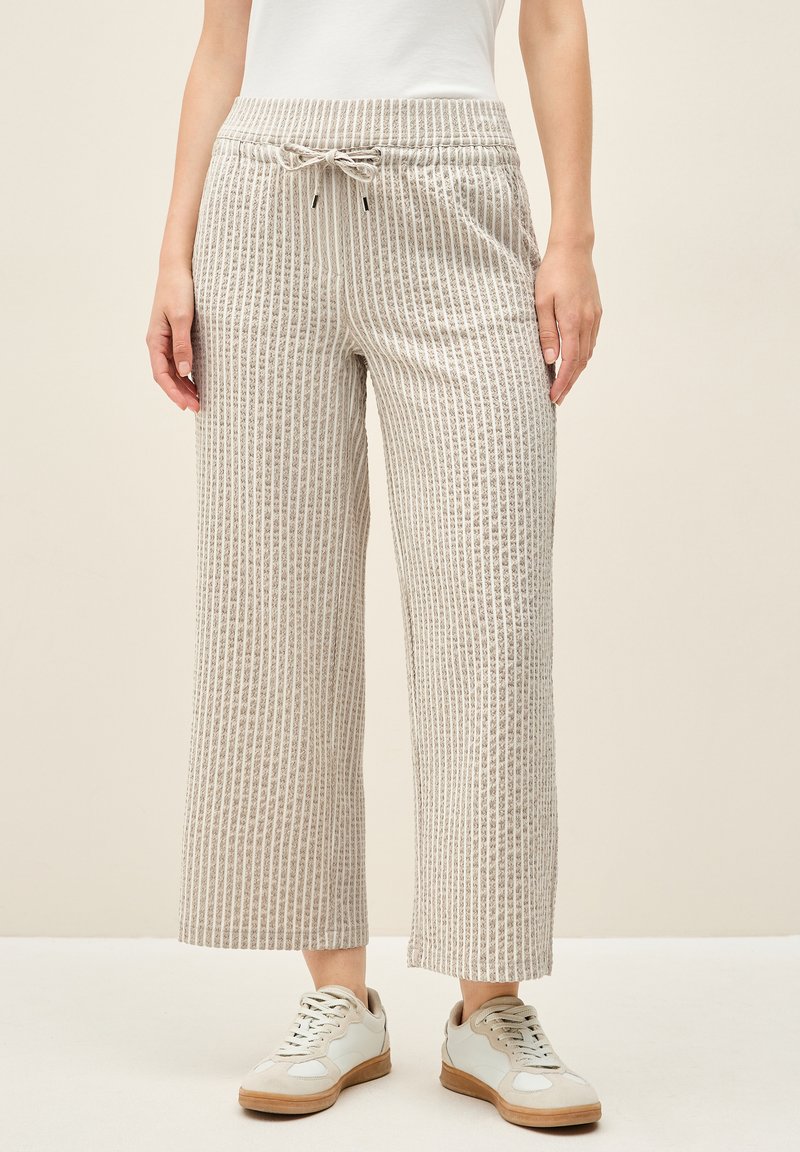 Lichtbeige wijde broek met verticale strepen en een gestructureerde stof. Beschikt over een elastische tailleband met een trekkoord en zijzakken.